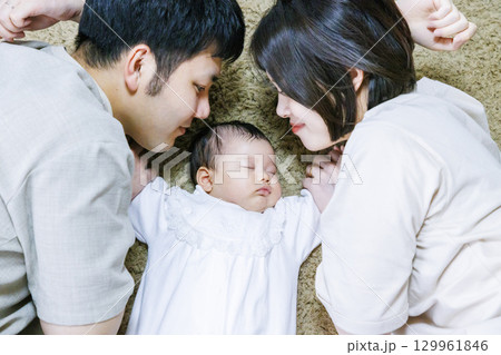 両親と一緒に寝転ぶ赤ちゃん 129961846