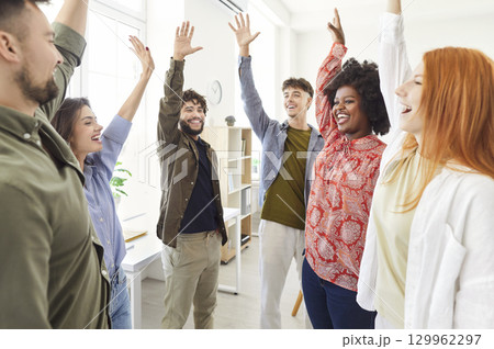 Multinational Business Team Celebrating Success With Raised Hands In The Office Multinational Business Team Celebrating Success With Raised Hands In The Office 129962297