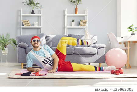 Funny happy sportsman relaxing pose doing body rest on floor, sitting to exercise, playful fitness 129962303