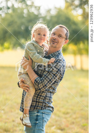 Young father and funny little daughter spending time together in autumn park at sunset light of Prague, Europe Young father and funny little daughter spending time together in autumn park at sunset light of Prague, Europe 129962936