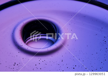 Beautiful texture of cosmetic oil on a purple background. Beautiful texture of cosmetic oil on a purple background. 129963051