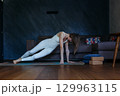 woman moving into Side Plank Tree yoga pose at home 129963115