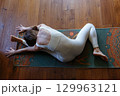 high angle view of a woman at home doing yoga Head to Knee Pose 129963121