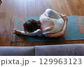 high angle view of a woman at home doing yoga 129963123
