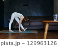 woman exercising at home doing yoga 129963126