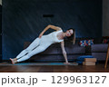woman standing in Side Plank yoga pose at home 129963127