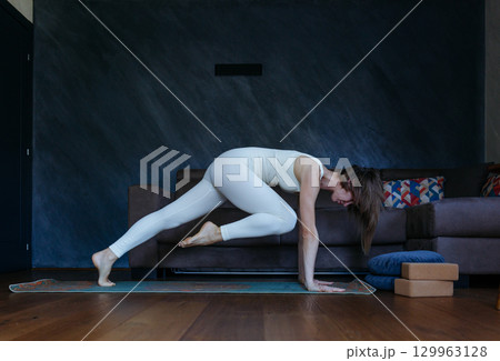 woman doing Forearm Plank yoga pose at home 129963128