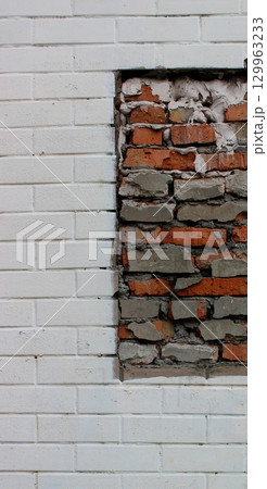 Pattern of white brick wall with part of rough brickwork on it texture background 129963233
