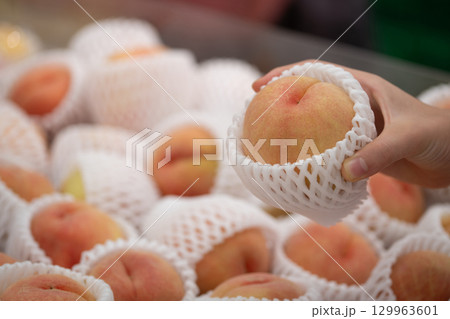 桃を持った手 129963601