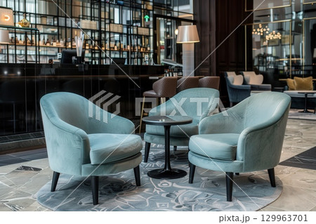 Modern blue armchairs and small table in stylish hotel lobby interior with elegant design.  129963701