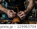 Close-up of skilled cobbler repairing a leather boot by hand. Traditional craftsmanship and artisan work concept. 129963704