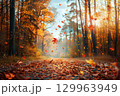 Colorful autumn leaves falling in a sunlit forest path, glowing with warm light and seasonal atmosphere. 129963949