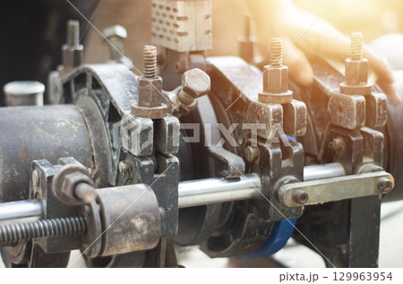 Plumbers use tools to connect large water pipes. 129963954