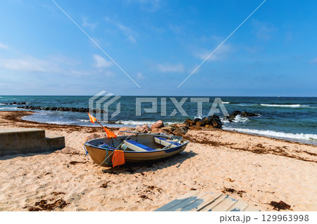 Sea sand beach with boats and blue sky with clouds 129963998