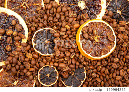 Coffee beans and dried orange slices create a unique aromatic blend in a decorative arrangement Coffee beans and dried orange slices create a unique aromatic blend in a decorative arrangement 129964285