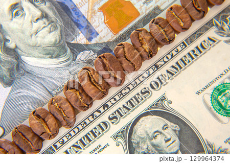 Coffee beans arranged on a US dollar bill illustrating the value of a good brew 129964374