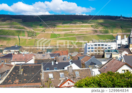 Beautiful city panorama with houses, river, vineyards, viewed from above surrounded by mountains in summer time. Beautiful city panorama with houses, river, vineyards, viewed from above surrounded by mountains in summer time. 129964834