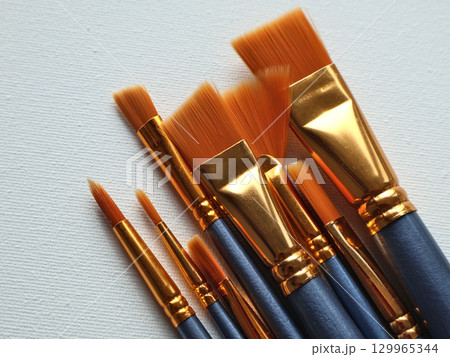 Set of Professional Artist Brushes on Blank Canvas Ready for Painting 129965344