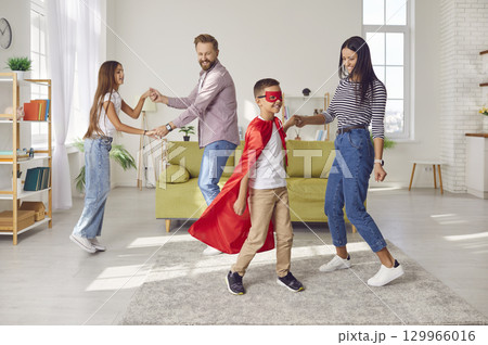 Full length photo of a happy family having fun with children in the living room at home. Full length photo of a happy family having fun with children in the living room at home. 129966016