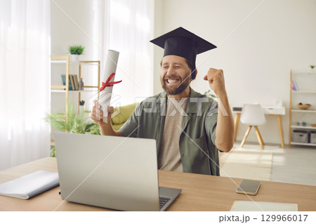 Happy Graduate Online Celebrates with Diploma and Laptop Happy Graduate Online Celebrates with Diploma and Laptop 129966017
