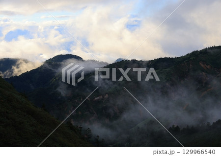霧に包まれる山の稜線 129966540