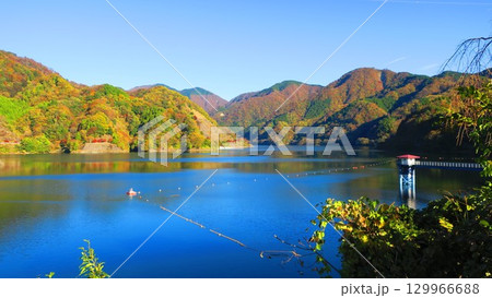 秋の紅葉が彩り、湖が鏡となって映り込む晴天の日 秋の紅葉が彩り、湖が鏡となって映り込む晴天の日 129966688