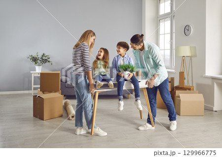 Happy family on moving day on a new home with unpacked boxes. Happy family on moving day on a new home with unpacked boxes. 129966775