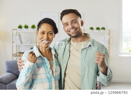 Woman and man embracing and clenching fists, having positive mood, feeling glad, working as team 129966793