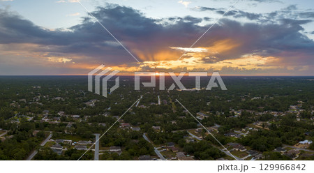 Aerial landscape view of suburban private houses between green palm trees in Florida quiet rural area at sunset 129966842