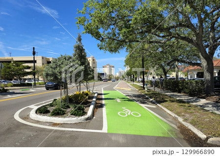 Designated green bike lane on busy Sarasota street in Florida, bordered by traffic and promoting sustainable urban transportation 129966890