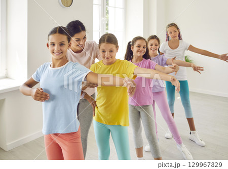 Group of happy, smiling little children learning some ballet at a dancing studio 129967829