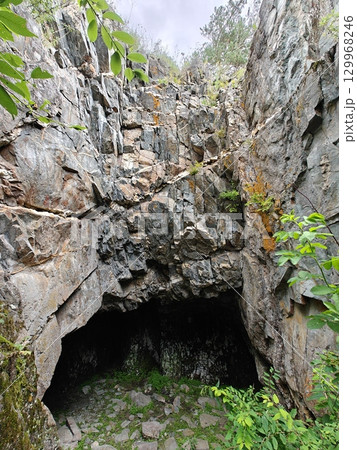 Mysterious Cave Entrance Amidst Rocky Terrain A Geological Wonder and Natural Hideaway Mysterious Cave Entrance Amidst Rocky Terrain A Geological Wonder and Natural Hideaway 129968246