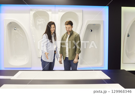 Couple choosing bathtub for bathroom in their house standing at building market planning repair. 129968346