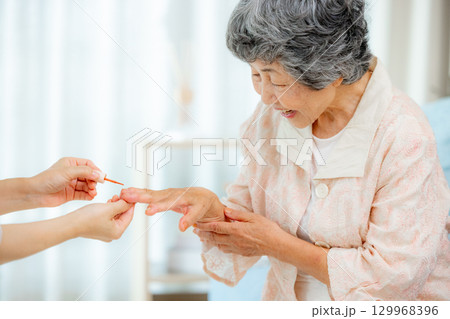 ネイルをするシニア女性 129968396