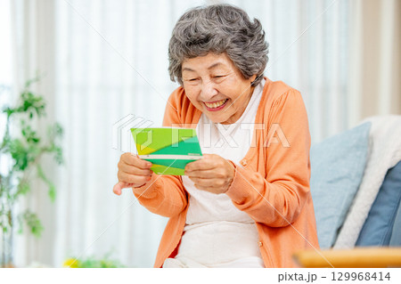 預金通帳を持つシニア女性 129968414