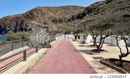 A stunning and scenic coastal pathway located beautifully near majestic mountains and the sea 129968647