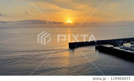 A Serene Sunset Over Calm Waters at the Beautiful Harbor Offers a Truly Breathtaking View 129968655