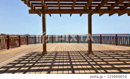 Enjoy a stunning ocean view from a spacious deck adorned with a beautiful pergola 129968658