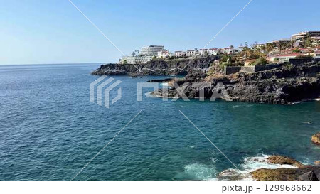 Stunning Coastal View Featuring Serene Waters Surrounded by Majestic Rocky Cliffs 129968662