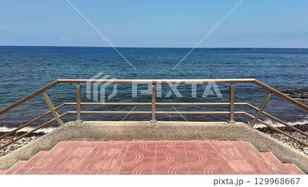 Experience a breathtaking and scenic view of the ocean from a charming coastal boardwalk Experience a breathtaking and scenic view of the ocean from a charming coastal boardwalk 129968667