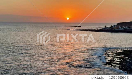 A Breathtaking, Stunning Sunset Over the Calm Ocean Waters Captured Perfectly in Time 129968668