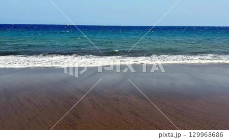 Experience the serene beauty of beach waves and enjoy the crystal clear waters at the shore Experience the serene beauty of beach waves and enjoy the crystal clear waters at the shore 129968686