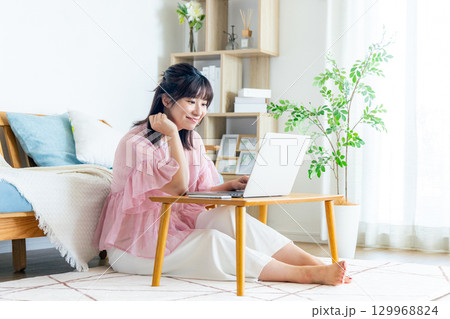 リビングでパソコンを使う女性 129968824