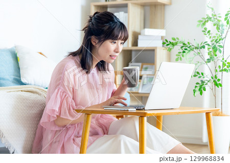 リビングでパソコンを使う女性 129968834