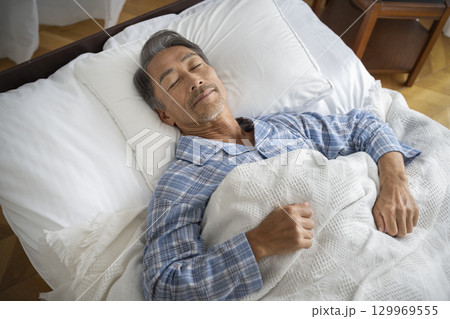 ベッドで眠る60代の男性 129969555