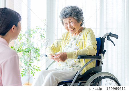 介護施設で働く若いヘルパー 介護施設で働く若いヘルパー 129969611