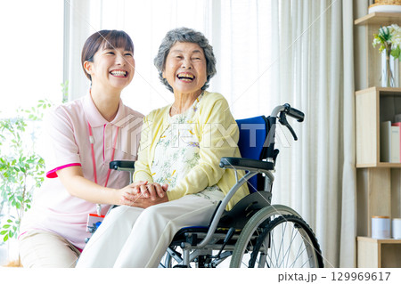 介護施設で働く若いヘルパー 介護施設で働く若いヘルパー 129969617