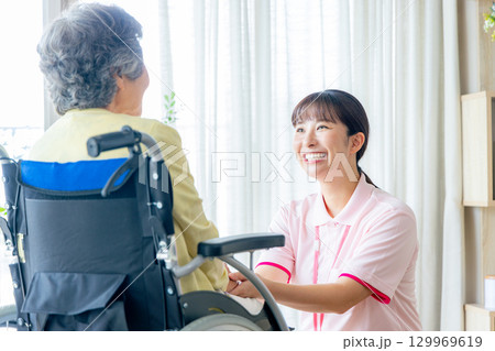 介護施設で働く若いヘルパー 介護施設で働く若いヘルパー 129969619
