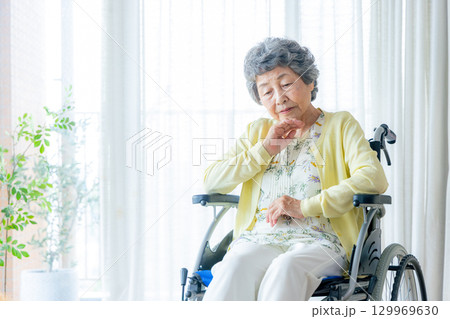 車椅子に乗るシニア女性　悩む 129969630