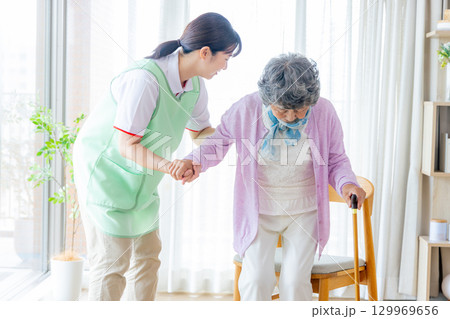 介護イメージ 杖をついて歩くシニア女性と介護士 介護イメージ 杖をついて歩くシニア女性と介護士 129969656